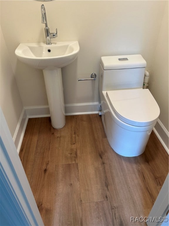 bathroom featuring hardwood / wood-style floors and toilet