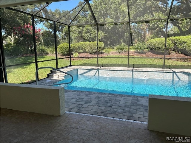 view of pool with a lawn and glass enclosure