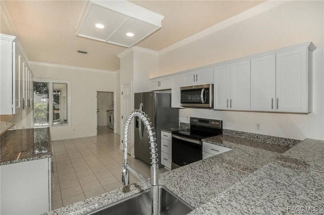 kitchen featuring white cabinetry, appliances with stainless steel finishes, and dark stone counters