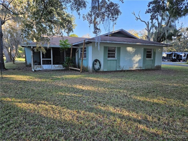 view of front of house with a sunroom and a front yard