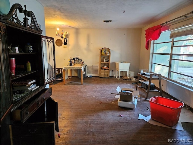 miscellaneous room featuring hardwood / wood-style floors and an inviting chandelier