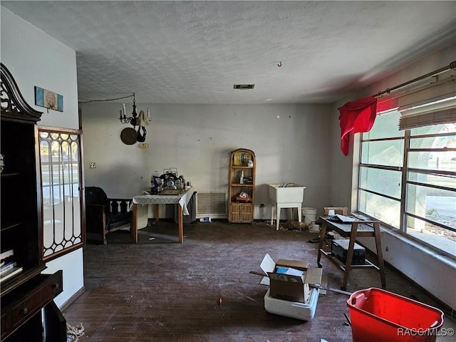 miscellaneous room with a textured ceiling and dark hardwood / wood-style flooring