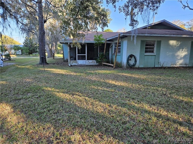 back of property with a sunroom and a yard