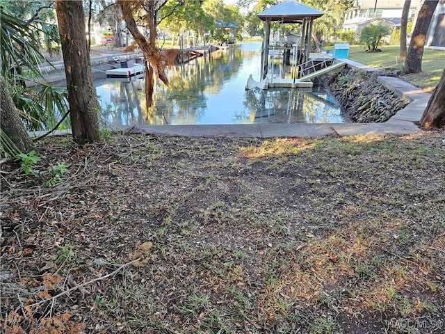 view of yard with a dock and a water view