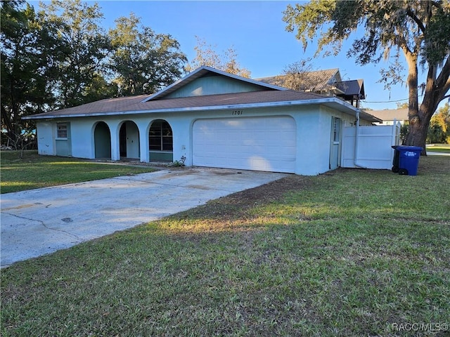 single story home featuring a front lawn and a garage