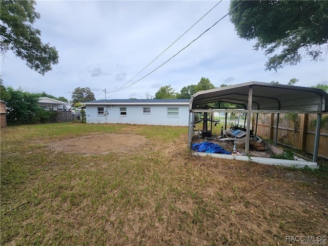 view of yard with fence and a detached carport