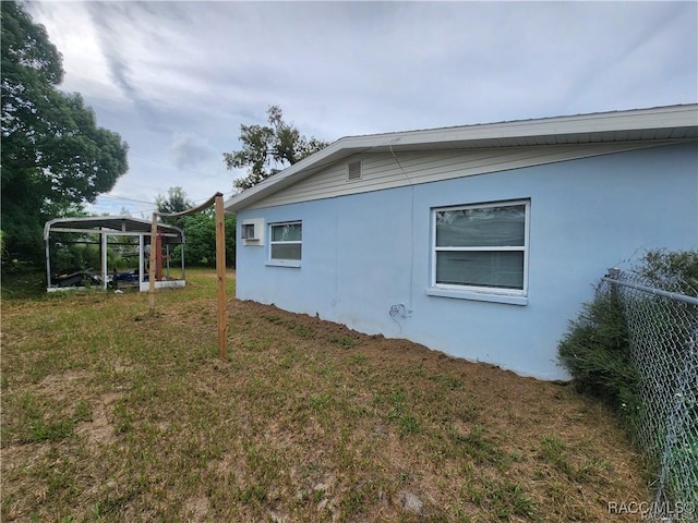 view of side of home with a yard and stucco siding