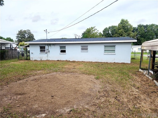 rear view of house with fence and a yard