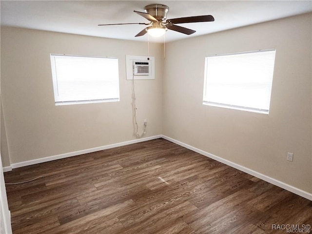 unfurnished room with a wall mounted air conditioner, ceiling fan, baseboards, and wood finished floors