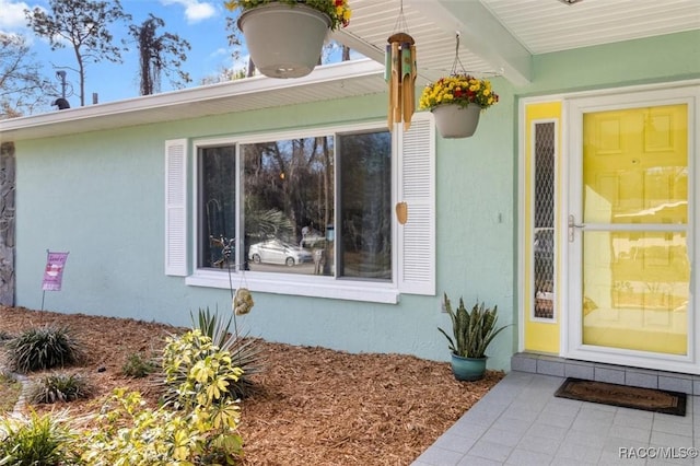 doorway to property featuring stucco siding