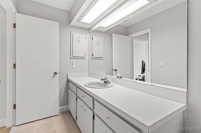 bathroom with baseboards, vanity, and tile patterned floors