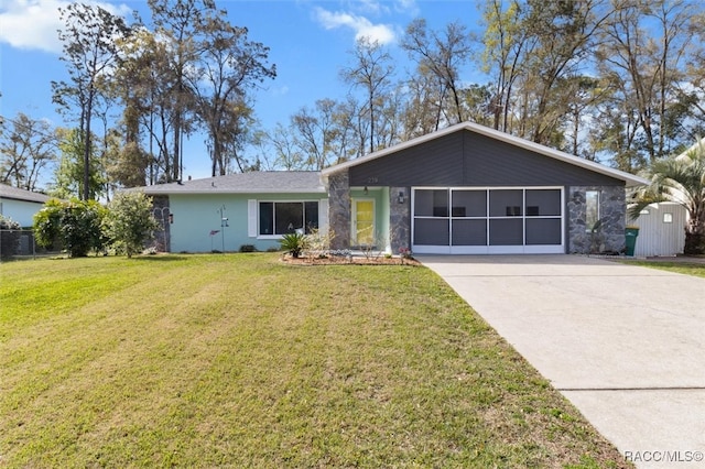 view of front of house featuring an attached garage, driveway, and a front lawn