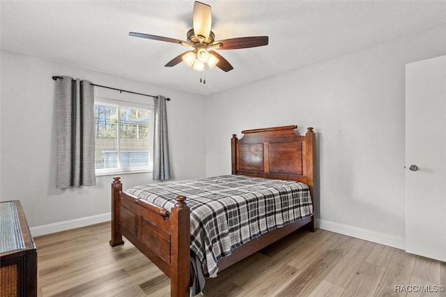 bedroom featuring wood finished floors, a ceiling fan, and baseboards