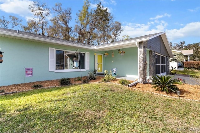 single story home with a garage, a front yard, and stucco siding