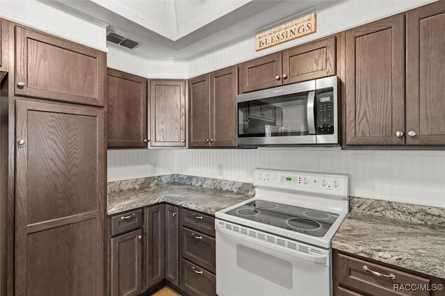 kitchen with dark brown cabinetry, electric range, visible vents, and stainless steel microwave