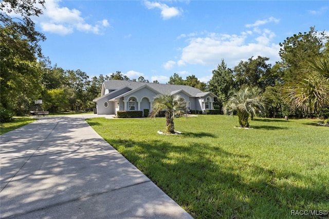 5705 N Bedstrow Blvd, Beverly Hills, FL 34465 - view of front of property with concrete driveway, a front yard, and stucco siding
