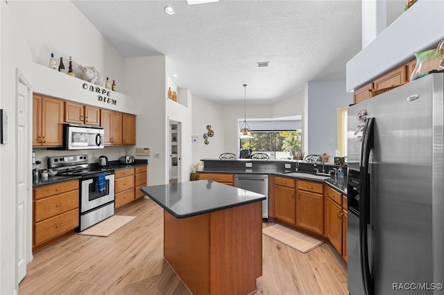5705 N Bedstrow Blvd, Beverly Hills, FL 34465 - kitchen featuring appliances with stainless steel finishes, a peninsula, dark countertops, a textured ceiling, and hanging light fixtures