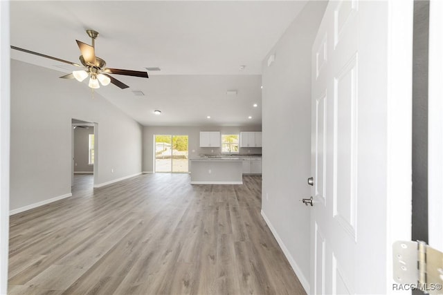 5674 N Claremont Dr, Citrus Springs, FL 34434 - unfurnished living room featuring baseboards, visible vents, ceiling fan, vaulted ceiling, and light wood-style floors