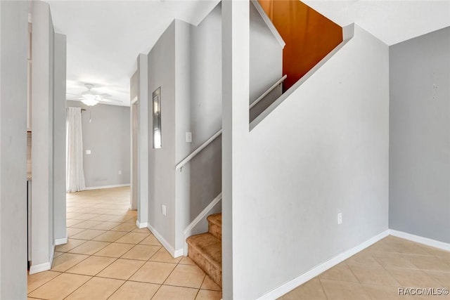 stairway featuring tile patterned floors and ceiling fan