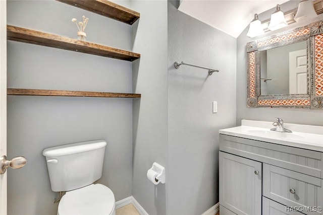 bathroom featuring vanity, lofted ceiling, and toilet