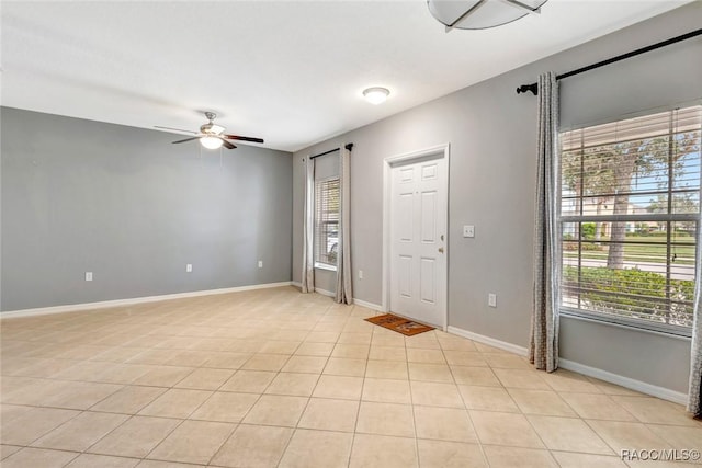 tiled empty room featuring ceiling fan