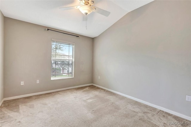 spare room with ceiling fan, light colored carpet, and vaulted ceiling