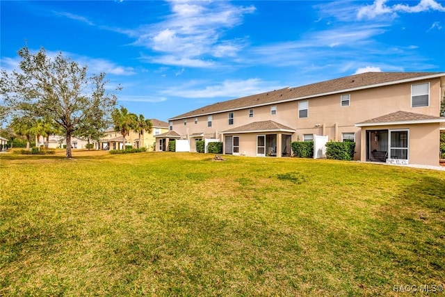 back of property featuring a lawn