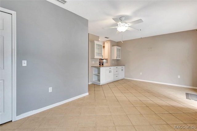 unfurnished living room with ceiling fan and light tile patterned floors