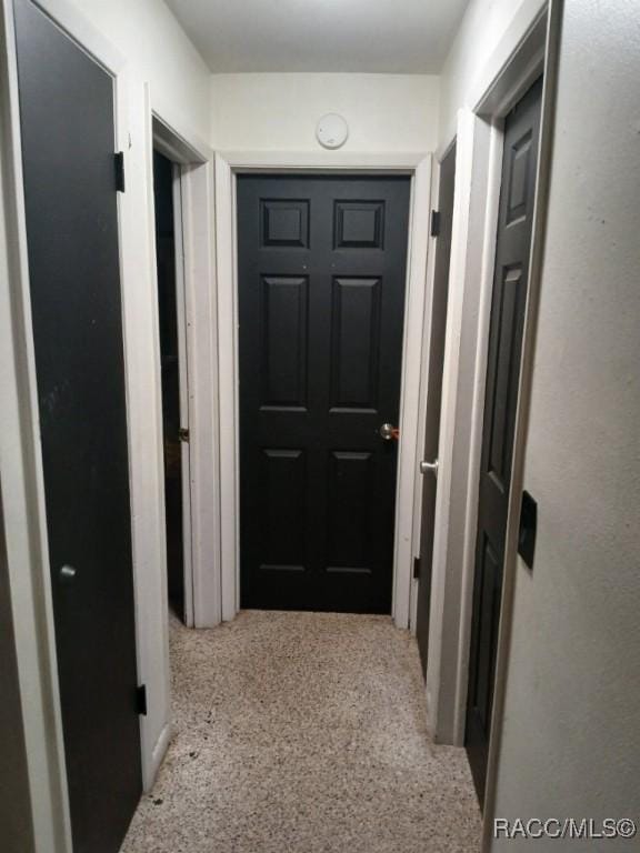 hallway featuring light speckled floor