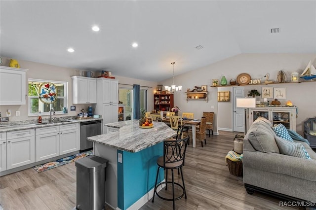 9973 N Chelic Dr, Citrus Springs, FL 34434 - kitchen with stainless steel dishwasher, a sink, open floor plan, a chandelier, and a kitchen bar