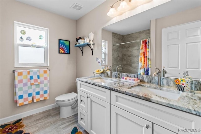 9973 N Chelic Dr, Citrus Springs, FL 34434 - full bathroom with double vanity, toilet, baseboards, and healthy amount of natural light