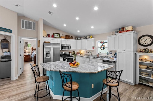9973 N Chelic Dr, Citrus Springs, FL 34434 - kitchen featuring appliances with stainless steel finishes, a sink, healthy amount of natural light, white cabinetry, and lofted ceiling