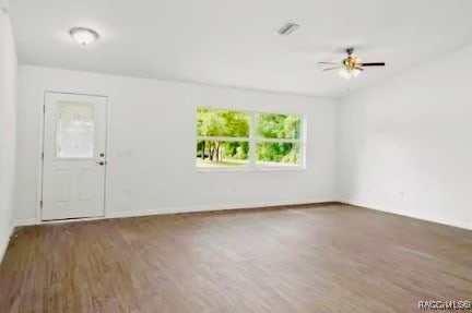 spare room with ceiling fan and dark wood-type flooring