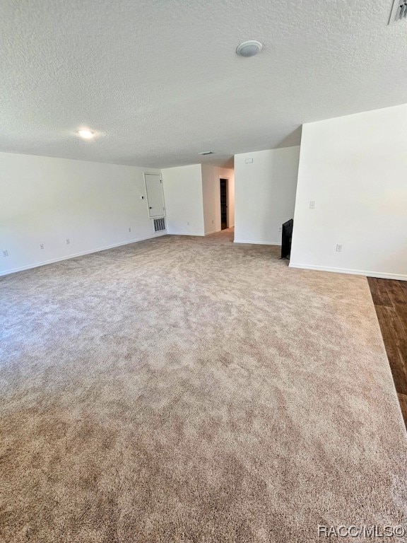 carpeted empty room featuring a textured ceiling