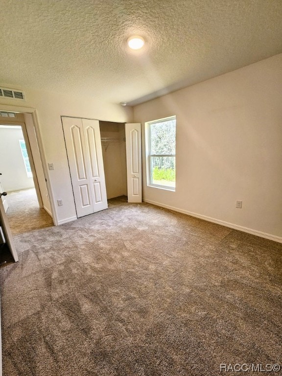 unfurnished bedroom with carpet and a textured ceiling