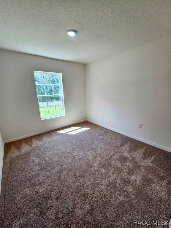 carpeted spare room with a textured ceiling