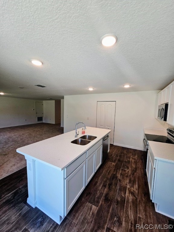 kitchen with dark hardwood / wood-style flooring, stainless steel appliances, a kitchen island with sink, and sink