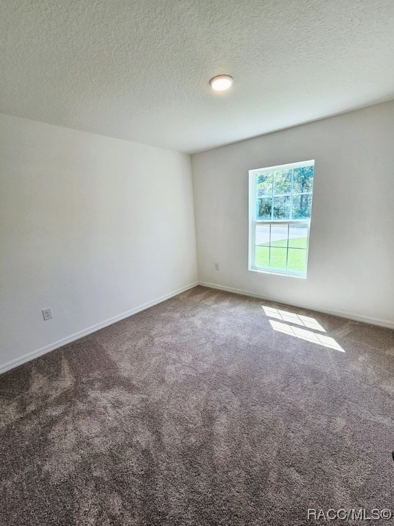 carpeted spare room featuring a textured ceiling