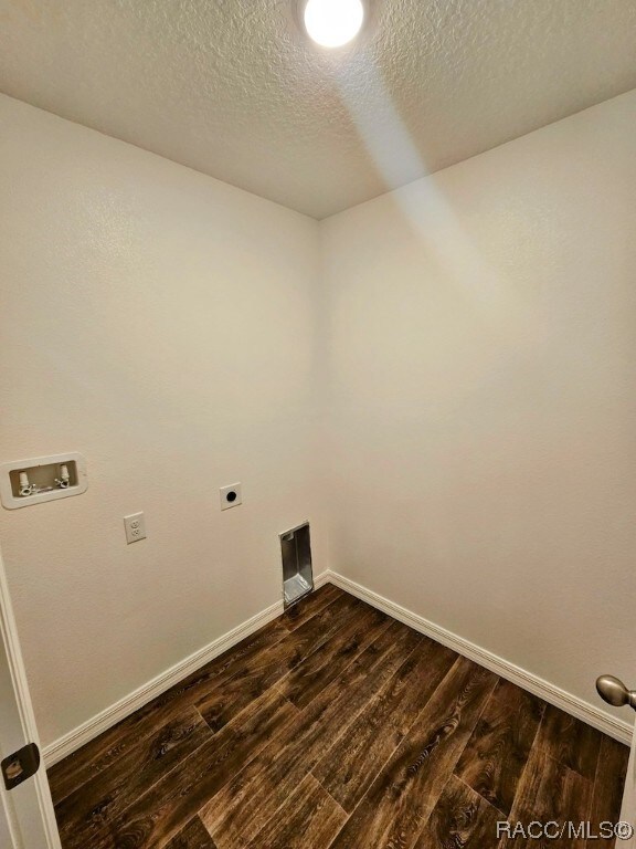 laundry area with hookup for an electric dryer, washer hookup, a textured ceiling, and dark hardwood / wood-style floors