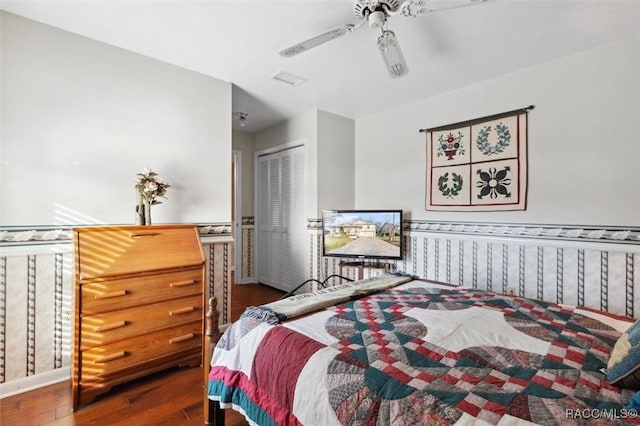 bedroom featuring dark hardwood / wood-style floors, ceiling fan, and a closet