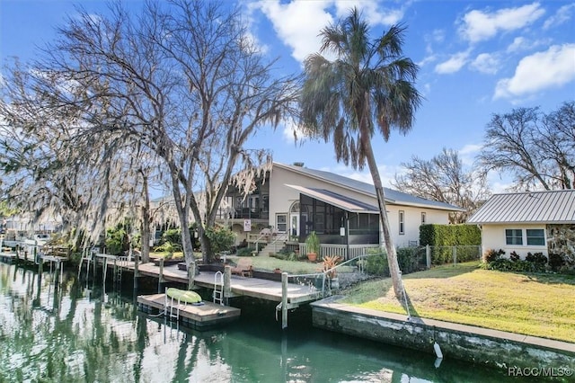 dock area with a water view and a yard