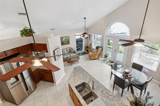 tiled living room featuring high vaulted ceiling, sink, ceiling fan, and french doors