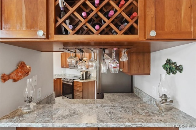 bar featuring stainless steel electric stove and light stone counters