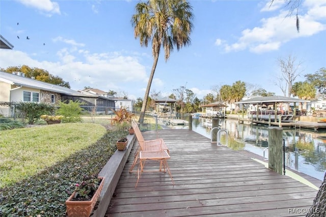 view of dock featuring a water view and a yard