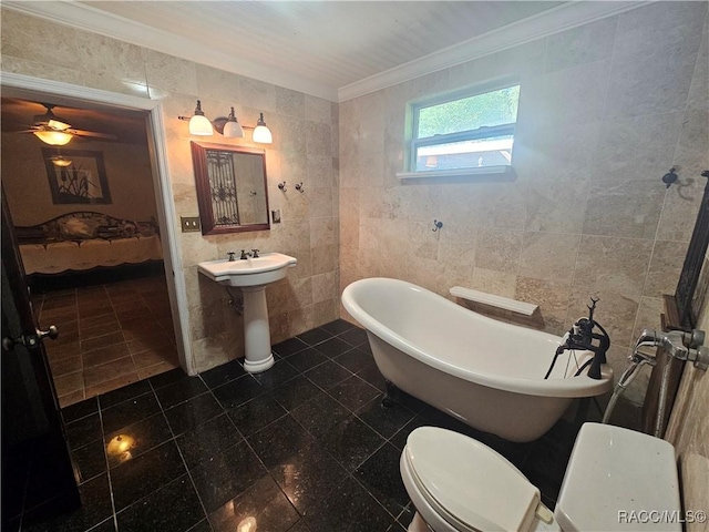 bathroom featuring a bathing tub, toilet, tile walls, and ornamental molding