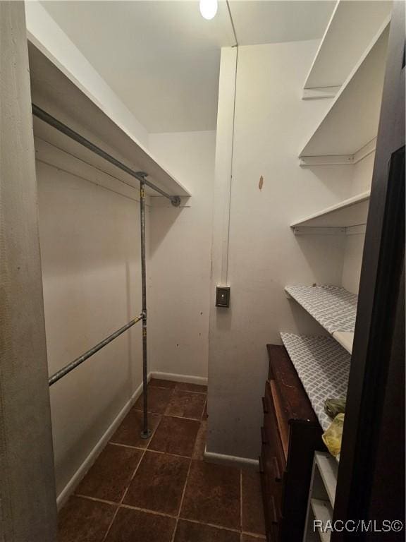 laundry room featuring dark tile patterned flooring