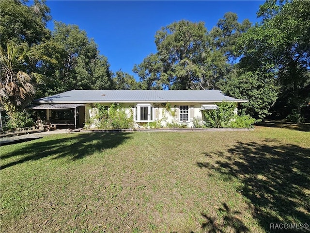 view of front of house with a front yard and a carport