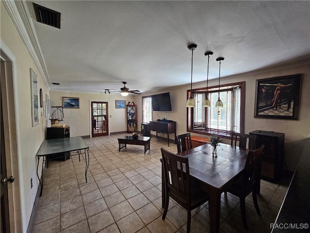 tiled dining area featuring ceiling fan, ornamental molding, and french doors