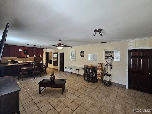 living room featuring ornamental molding, light tile patterned floors, ceiling fan, and wooden walls