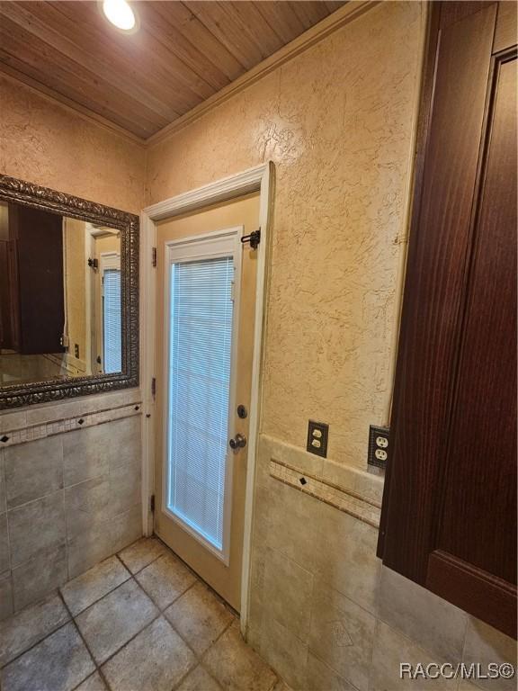 entryway featuring crown molding and wooden ceiling